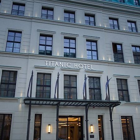 Titanic Gendarmenmarkt Berlín Exterior foto The photo shows the exterior of a building identified as the "Titanic Hotel." The facade features a clean, modern design with multiple windows and a prominent sign that displays the hotel name. There are decorative elements, including a covered entra