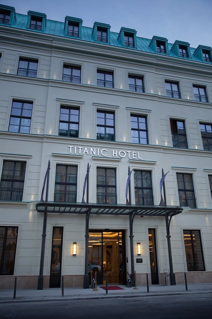 Titanic Gendarmenmarkt Berlín Exterior foto The photo shows the exterior of a building identified as the "Titanic Hotel." The facade features a clean, modern design with multiple windows and a prominent sign that displays the hotel name. There are decorative elements, including a covered entra